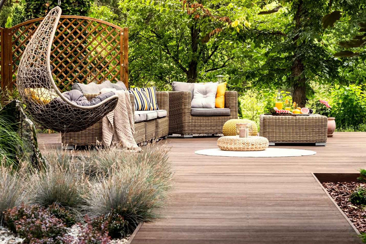 Terrassensteg mit Holzdielen führt zu Plattform in Garten auf der Gartenmöbel stehen