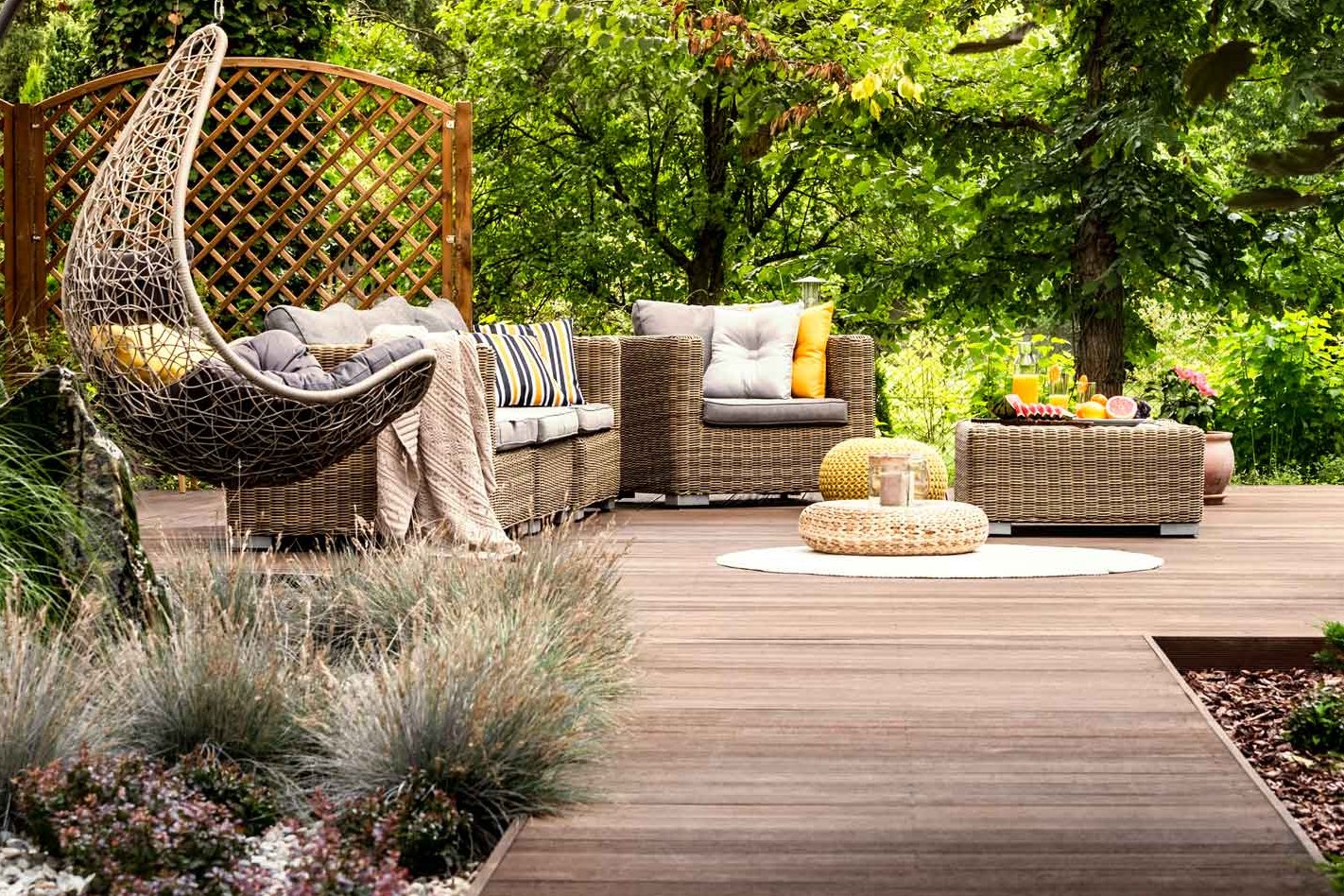 Terrassensteg mit Holzdielen führt zu Plattform in Garten auf der Gartenmöbel stehen